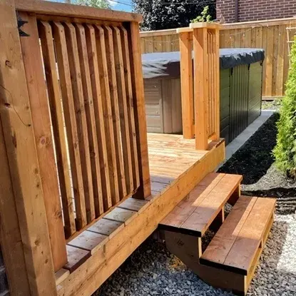 Custom deck steps beside a backyard hot tub